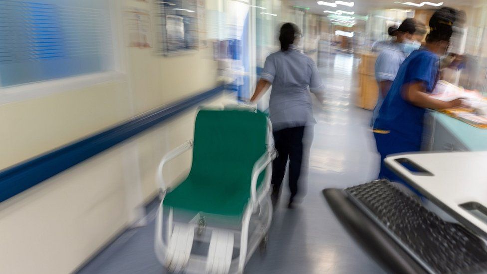 Staff moving through a hospital corridor