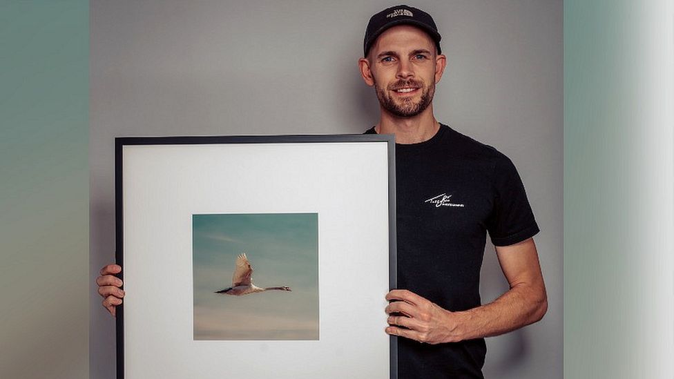 Taz Brotherton holding a framed photograph