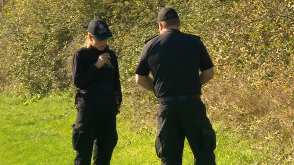 police officers searching woodland