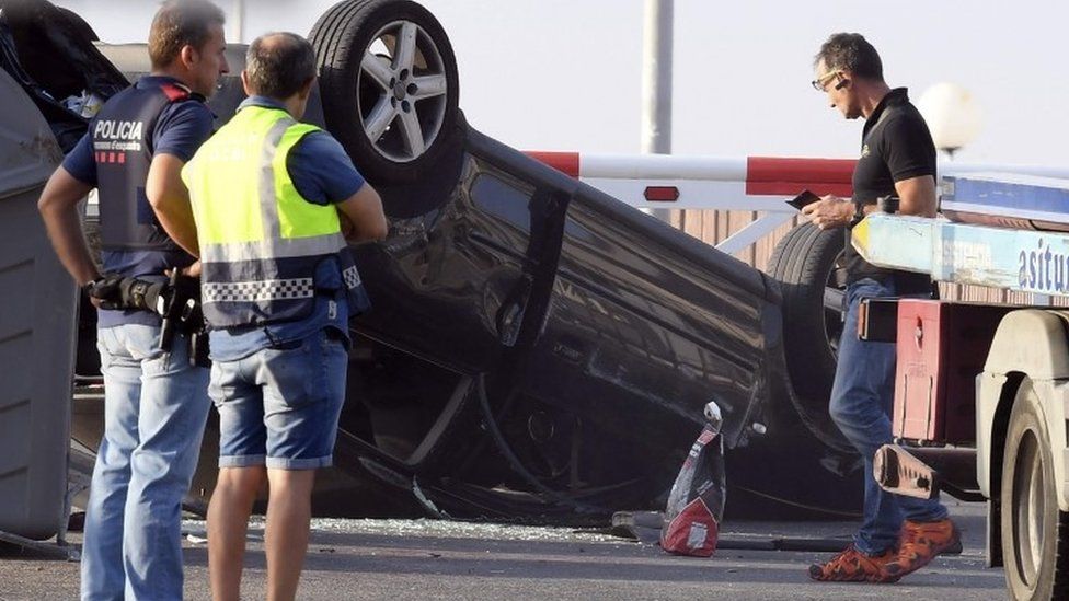 Policemen check the car involved in the attack in Cambrils