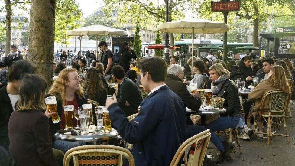 Customers drink beers at outdoor terraces in Paris