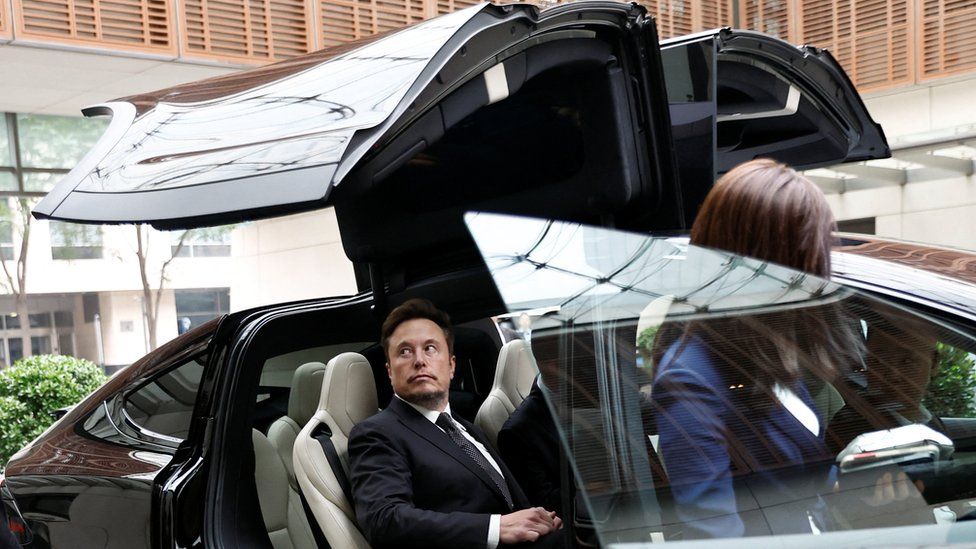 Elon Musk gets in a Tesla car as he leaves a hotel in Beijing, China on 31 May.