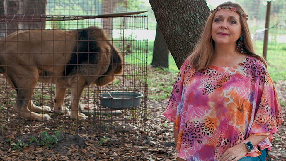 Carole Baskin and a lion in a cage