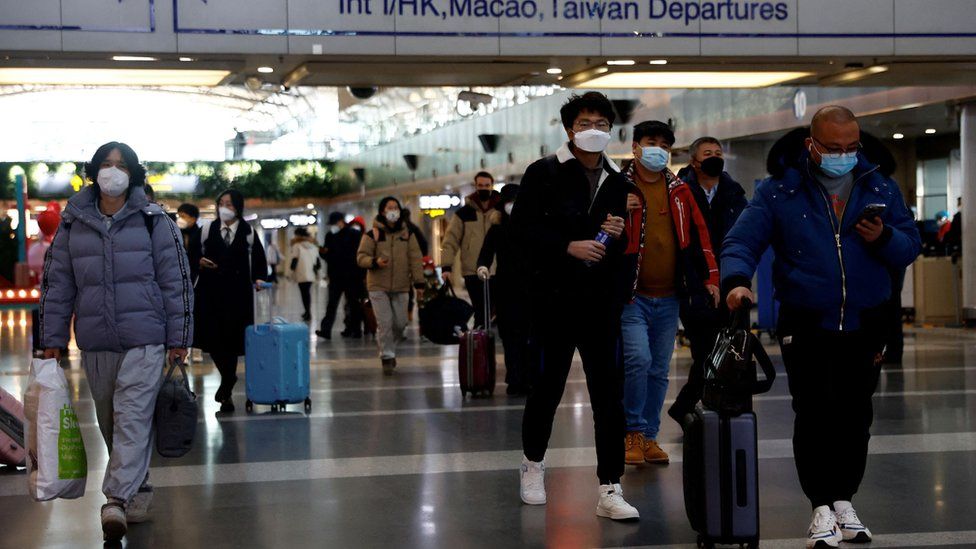 Travellers walking through Beijing's international airport on Tuesday 27/12