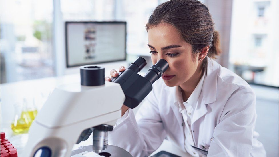 A scientist with a microscope (stock image)