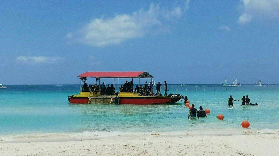 Tourists visit the beach on Boracay Island, Aklan province, on April 6, 2018