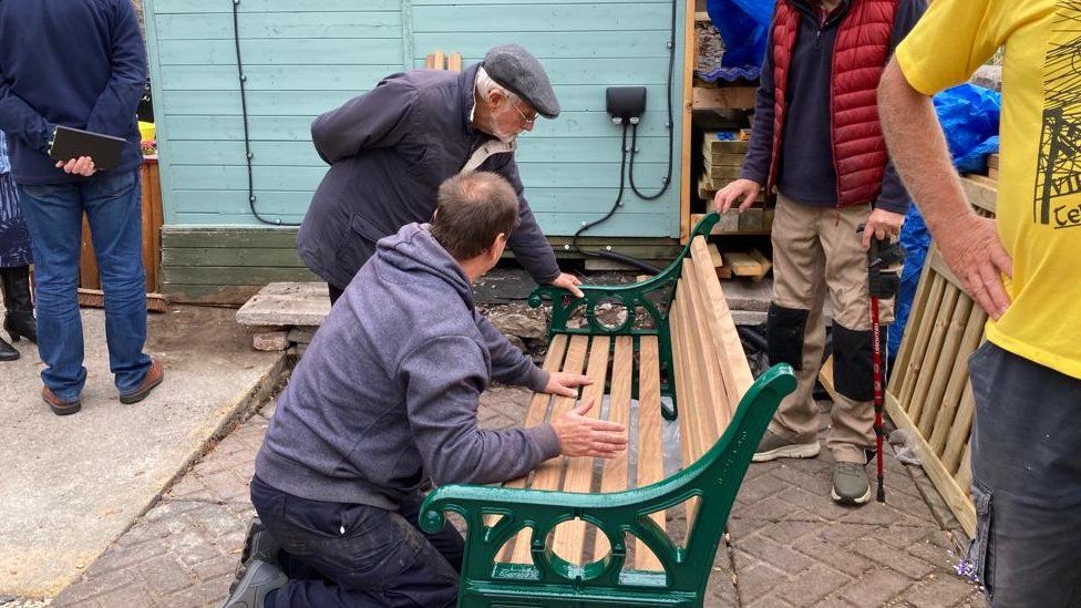 Paul Ruddock working on a bench with a friend