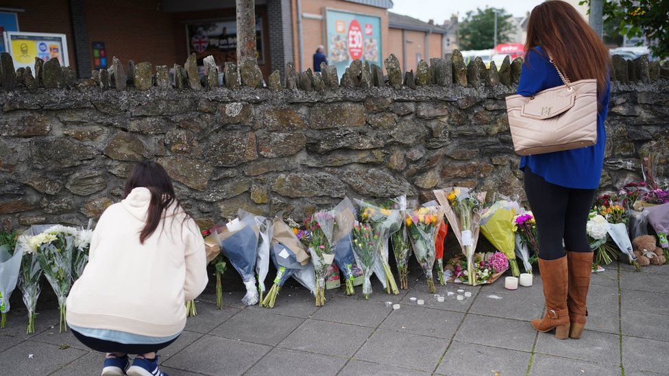 People leave flowers in the Keyham area of Plymouth after five people died in a shooting on 12 August 2021