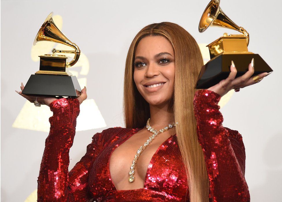 Beyonce holding up two Grammy awards in February 2017