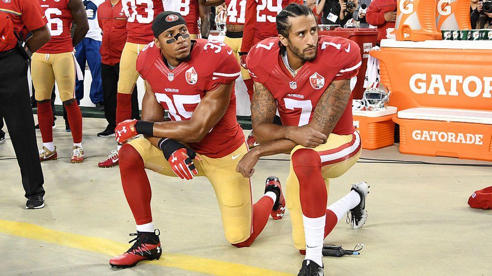 Colin Kaepernick (right) kneels during the Star Spangled Banner