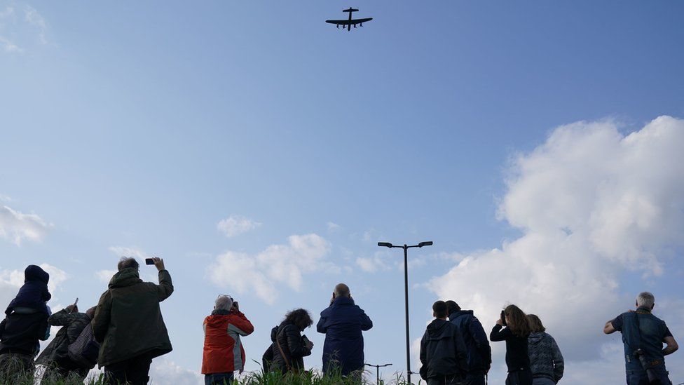 Spectators in Hendon watch the aircraft fly over the RAF Museum