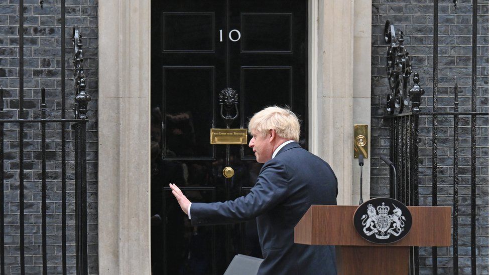 Mr Johnson waves as he turns towards the door at 10 Downing Street