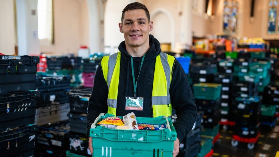 Chris Billam-Smith wearing a hi-vis vest and sorting food at Bournemouth Foodbank warehouse