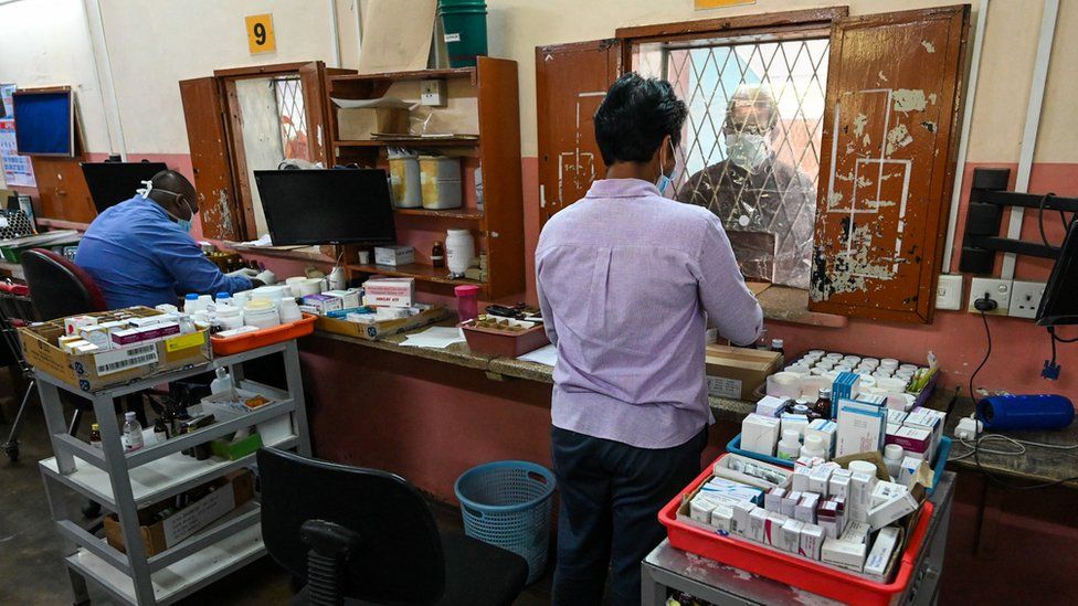 A pharmacist serves a man in a hospital in Colombo, Sri Lanka