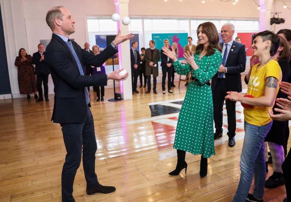 William juggles three balls as Kate and a circus performer watche on during their visit to Galway