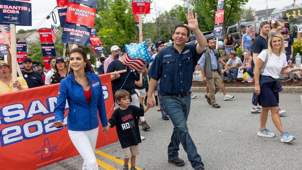 Ron DeSantis walks with his family at a 4 July parade in New Hampshire