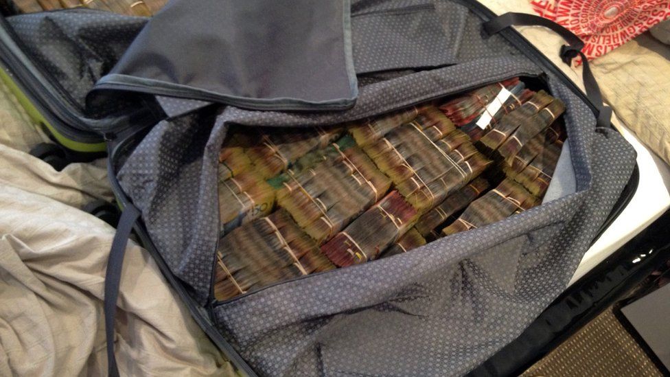 Связанные пачки денег в сумке во время наркорейда