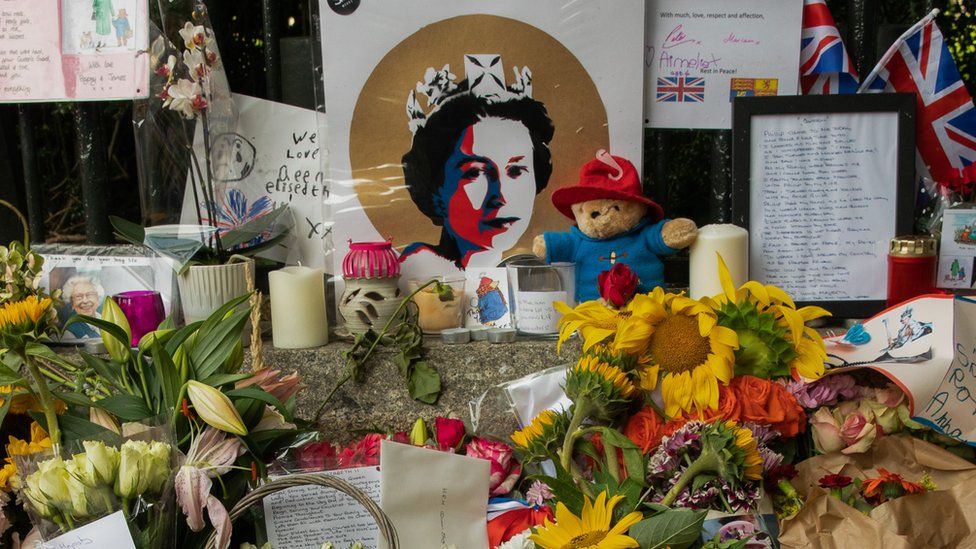 A Paddington Bear toy with a picture of the Queen and other tributes outside Cambridge Gate at Windsor Castle