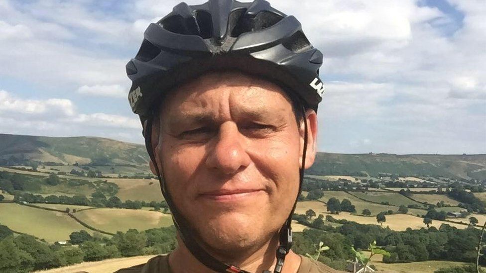 Stephen Mead wearing a cyclists helmet, taking a selfie