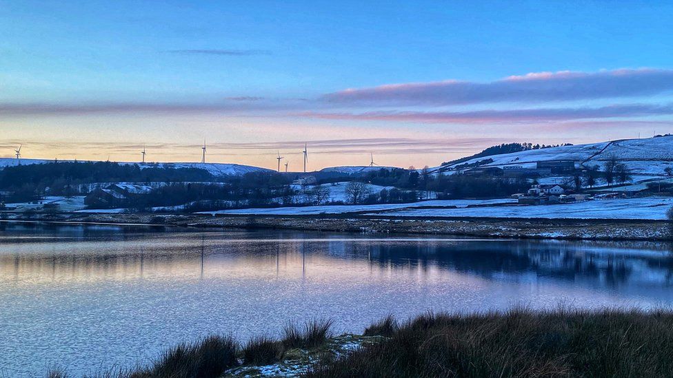 A snowy landscape reflected in water