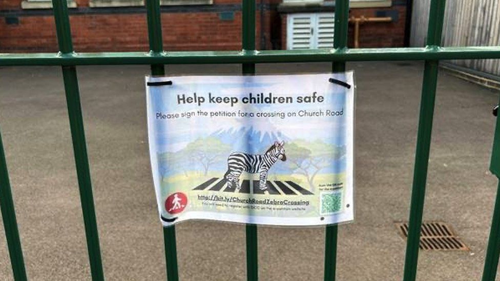 A poster advertising the petition hung on a gate at the school