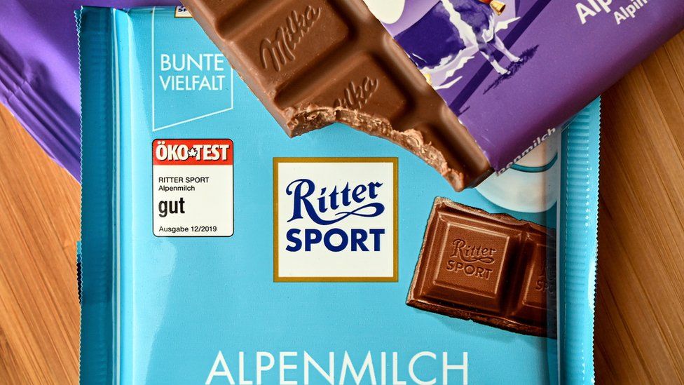 A divided bar of Milka chocolate in half lies on a Ritter Sport bar, in Duesseldorf, Germany, 17 July 2020