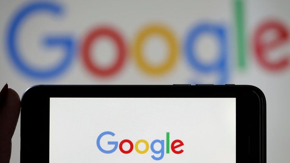 Изображение логотипа Google на экране телефона и ноутбука