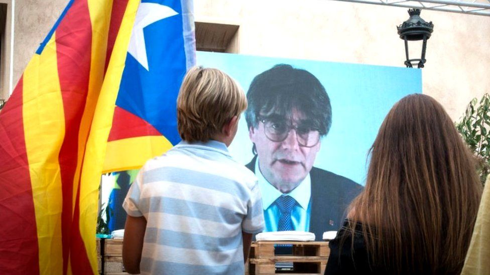 Ребенок наблюдает за телематическим вмешательством Пучдемона на центральном митинге вечеринки JxCAT 16 июля 2023 года в Амере, Жирона, Каталония, Испания.