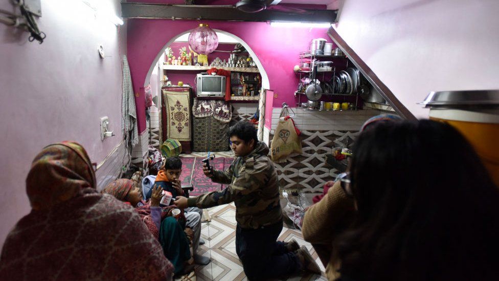 Скорбящие члены семьи 20-летней девушки, которую ночью 31 декабря затащила машина и убила в их дома в Султанпури, 2 января 2023 года в Нью-Дели, Индия.