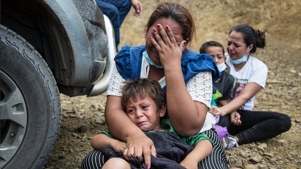 A migrant cries along with her child after police dispersed the caravan of thousands of people that blocked the road in Vado Hondo, Chiquimula, Guatemala, 18 January 2021