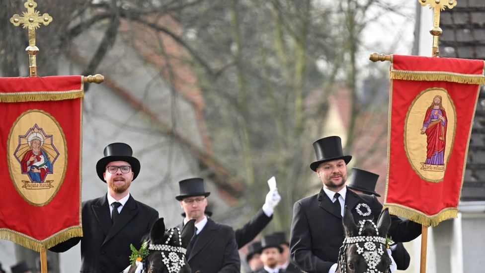 Men of Slavic ethnic minority of Sorbs, dressed in black tailcoats, ride decorated horses during an Easter rider procession in Ralbitz, eastern Germany