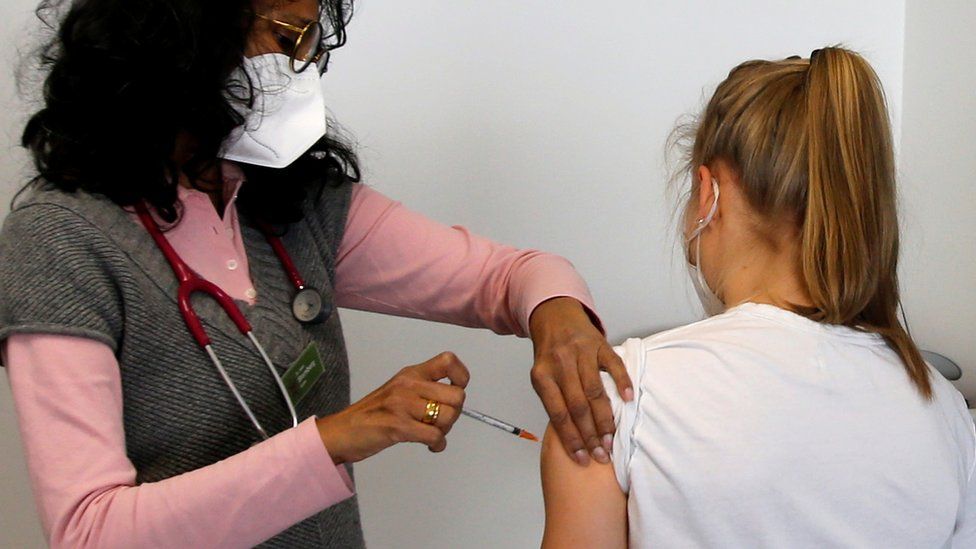 Pediatrician Anila Sternberg vaccinates a teenage girl with a dose of the Pfizer-BioNtech COVID-19 vaccine in her practice, as the spread of the coronavirus disease (COVID-19) continues, in Bonn, Germany, May 21, 2021