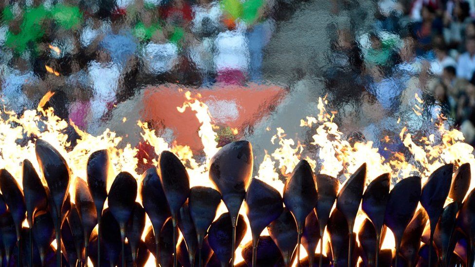 Coloured lights behind Olympic flame