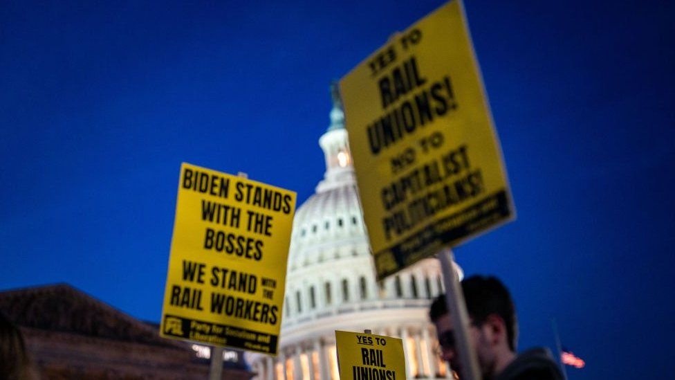 Signs outside the US Capitol that read 'Biden Stands with the Bosses, we Stand with the Rail Workers.'