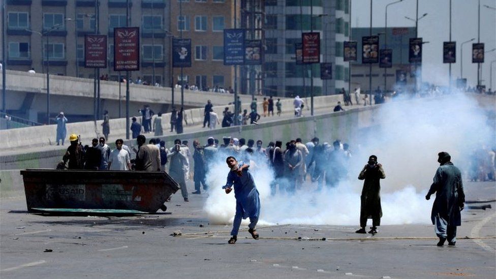 People throw stones at police during a protest against former Prime Minister Imran Khan"s arrest, in Peshawar, Pakistan, May 10, 2023.