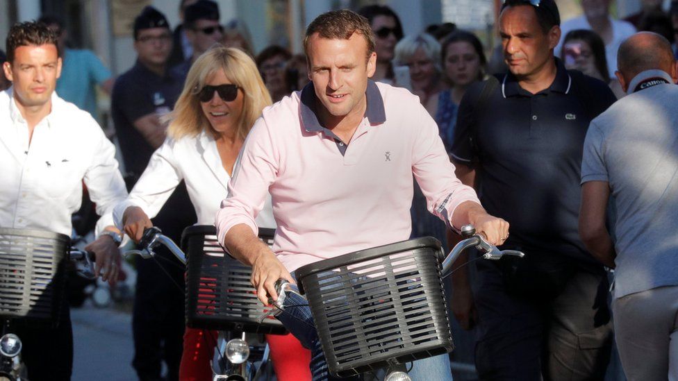 Emmanuel Macron and his wife, Brigitte Trogneux, riding bikes near their home on Saturday