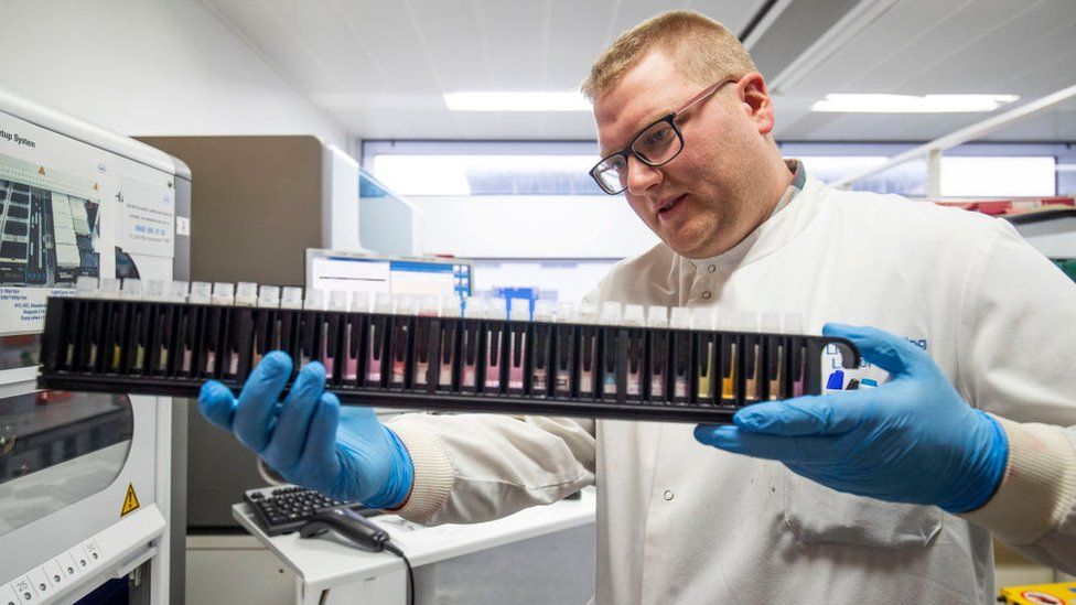 A technician extracts viruses from swab samples to try to identify coronavirus