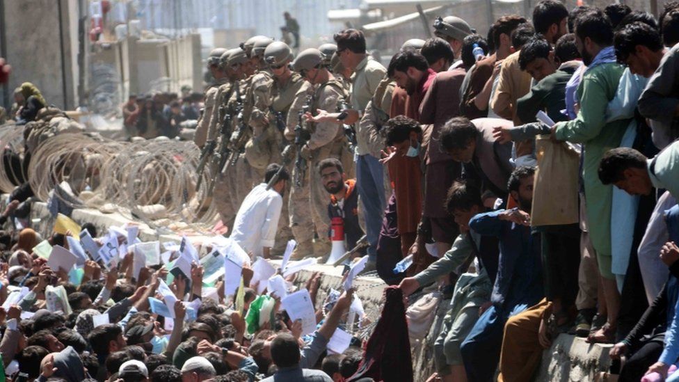 Afghans struggle to reach the foreign forces to show their credentials to flee the country outside the Hamid Karzai International Airport, in Kabul, Afghanistan, 26 August 2021