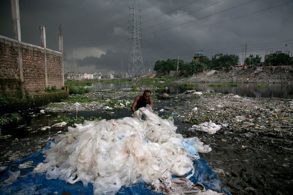 Bangladeş'in Dakka kentinde bir adam, Haziran ayında Buringanga nehrine çıkan bir kanalda kimyasal işlemden geçmiş plastik poşetleri yıkıyor. 2002 yılında Bangladeş, kanalizasyon sistemlerini tıkayarak sellere yol açtıklarının tespit edilmesi üzerine ince plastik poşetleri yasaklayan ilk ülke olmuştu.