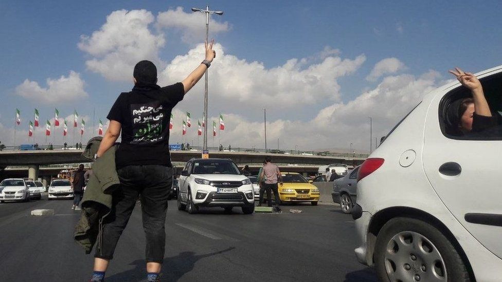 File photo showing a protester wearing a T-shirt saying "We will fight. We will die. We will take back Iran" and gesturing on a highway in Karaj, west of Tehran, on 3 November 2022