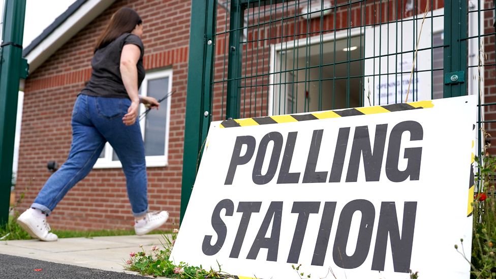 A member of polling station staff returns after putting up signs as polls open in the Selby and Ainsty by-election on 20 July 2023 in Selby, England