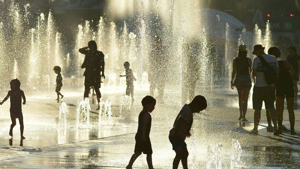 Montreal children cool off at a water fountain in the midst of a deadly heat wave