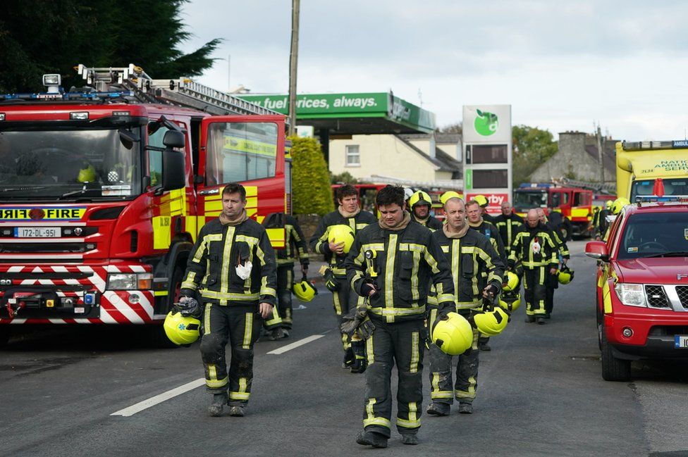 Firefighters leave the scene of the explosion at the service station in Creeslough