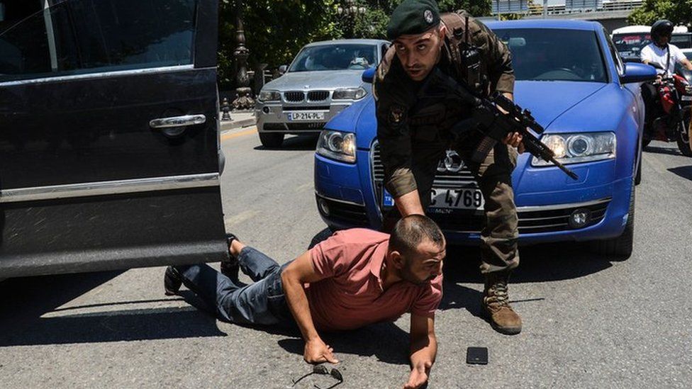 A Turkish police officer restrains a man on the ground during an operation in front of the Ankara courthouse - 18 July 2016.