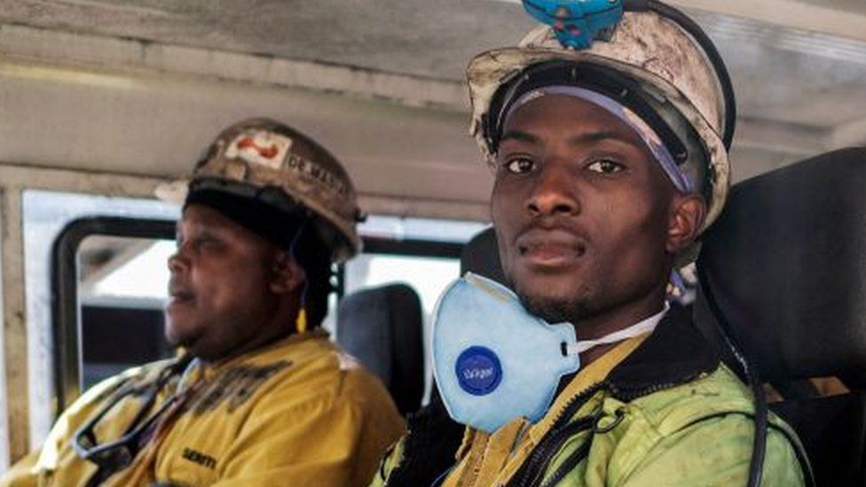 Miners are seen aboard the transport leading them to the start of their 12 hours shift in the Section A of the Khutala Colliery mine in Kendal, on September 29, 2022