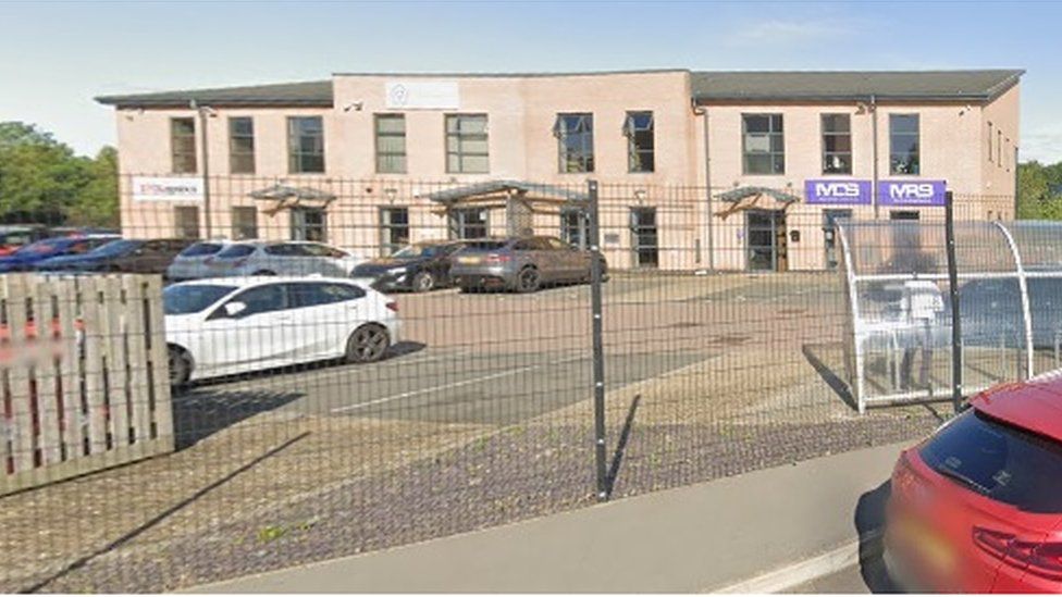 Two-storey brick building on an industrial estate. The PHG house logo is just visible at the top of the wall.