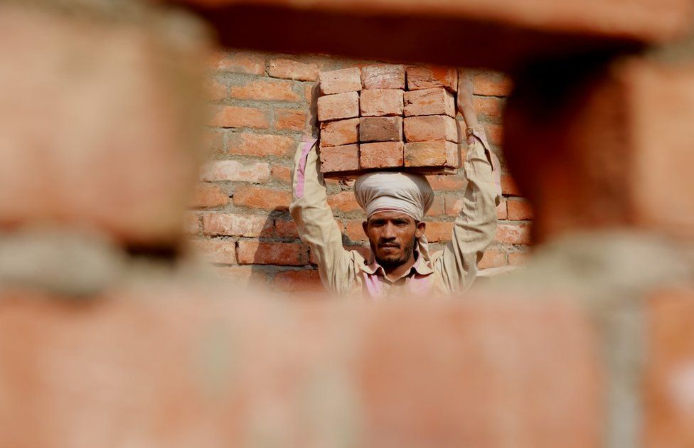 Ram Bhavan at a construction site carrying bricks