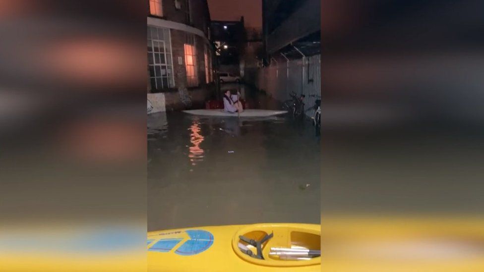Image from a video showing Rosie Lawrence's friend kayaked down a flooded street in Hackney Wick