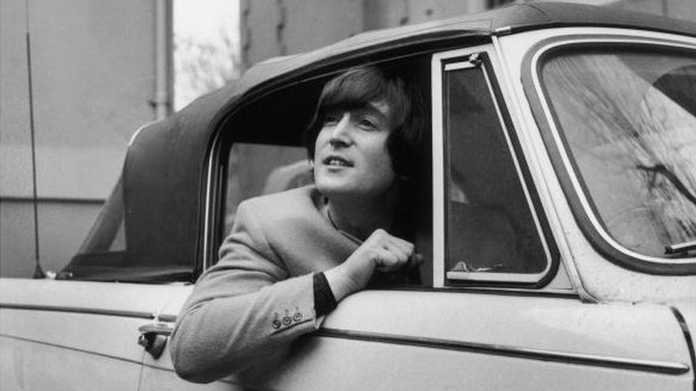 18th February 1965: Singer, songwriter and guitarist John Lennon of The Beatles in his Triumph Herald convertible car.