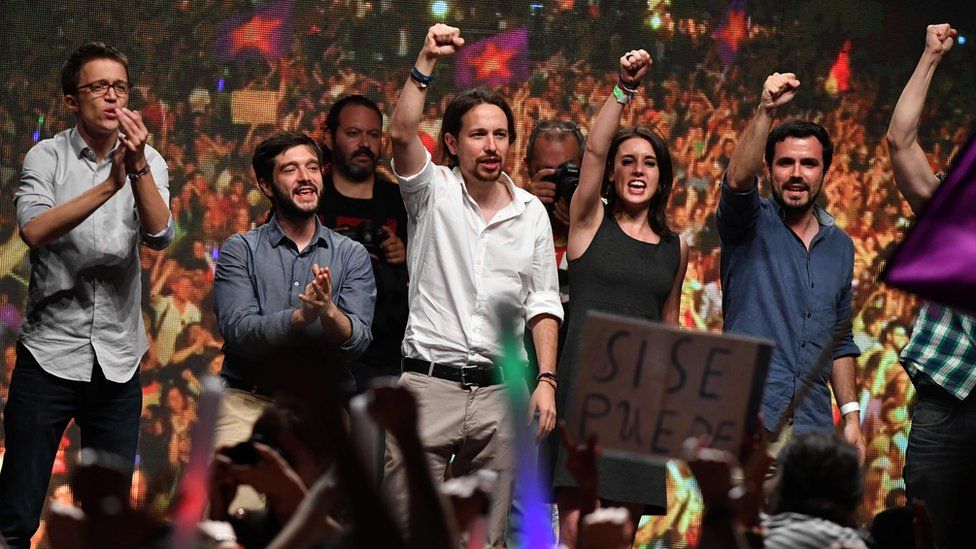 Leader of left-wing party Podemos, Pablo Iglesias (C) raises his fist with left-wing Podemos member and Madrid candidate Irene Montero (2nd R) and Left-wing party IU leader Alberto Garzon (R)